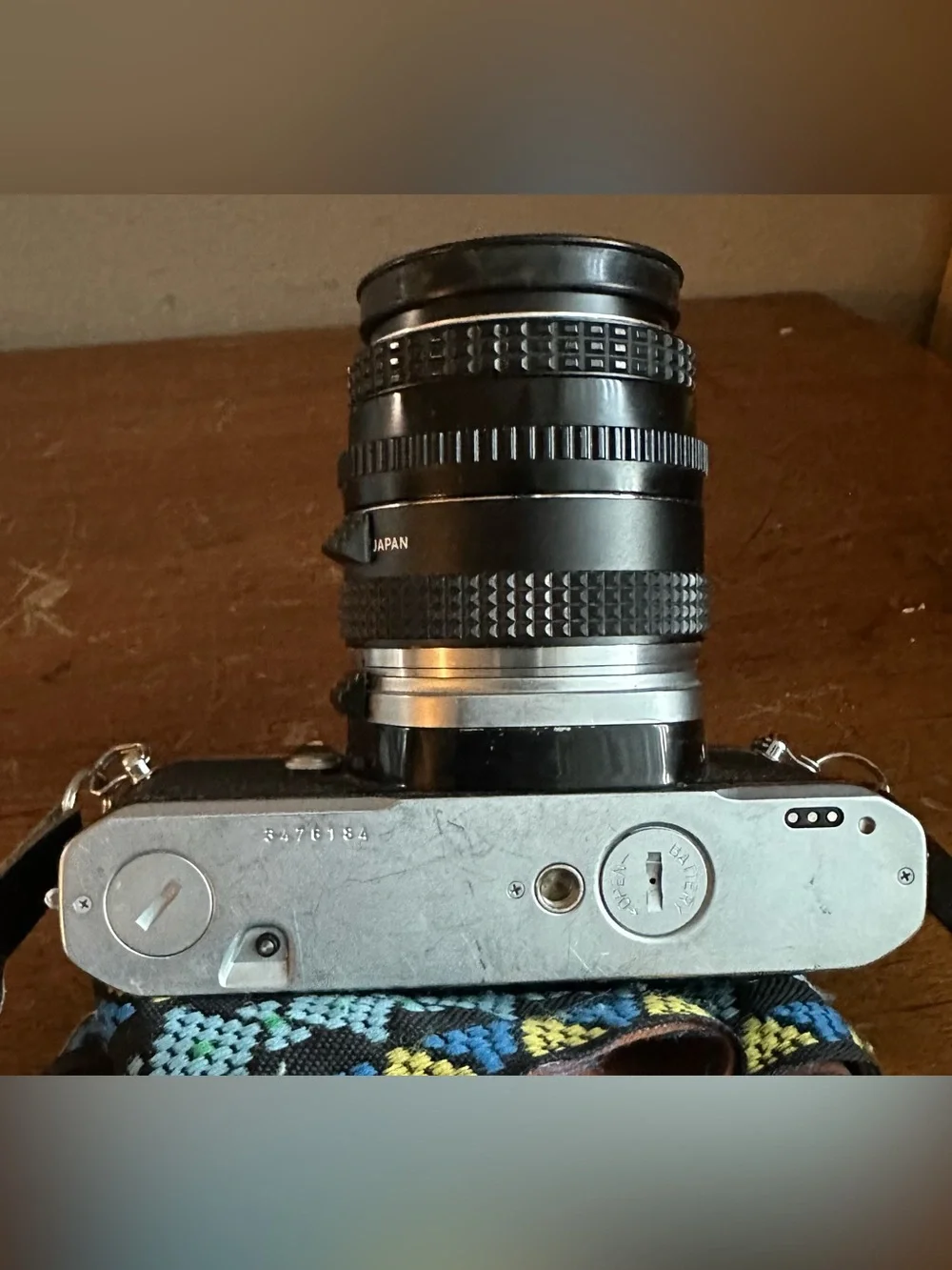 Pentax Silver and Black SLR Camera with Black Lens Cap and Colorful Strap